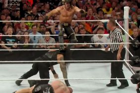 Seth Rollins curb stomps Roman Reigns as Brock Lesnar lies in the ring at WrestleMania 31
